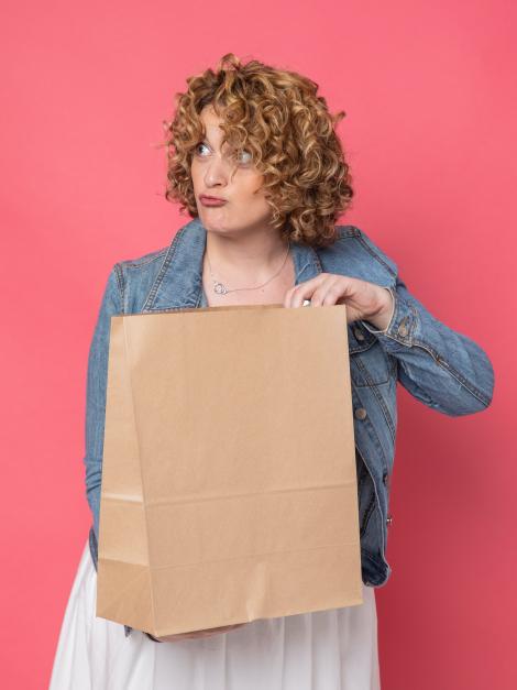 Una mujer sujetando las bolsas de papel sin asas
