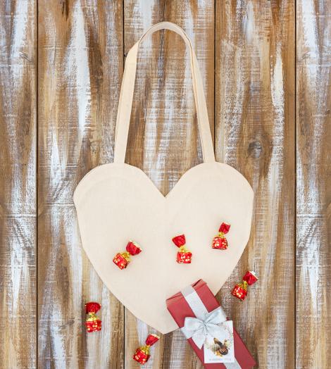 Bolsas de algodón orgánico en forma de corazón con caramelos alrededor