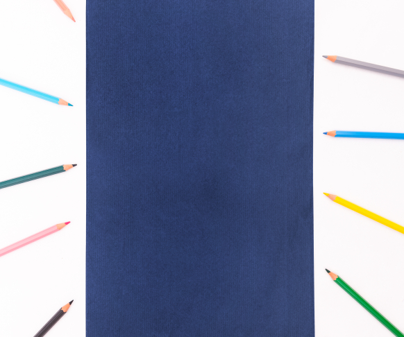 Sobres de papel de color azul marino con lápices alrededor