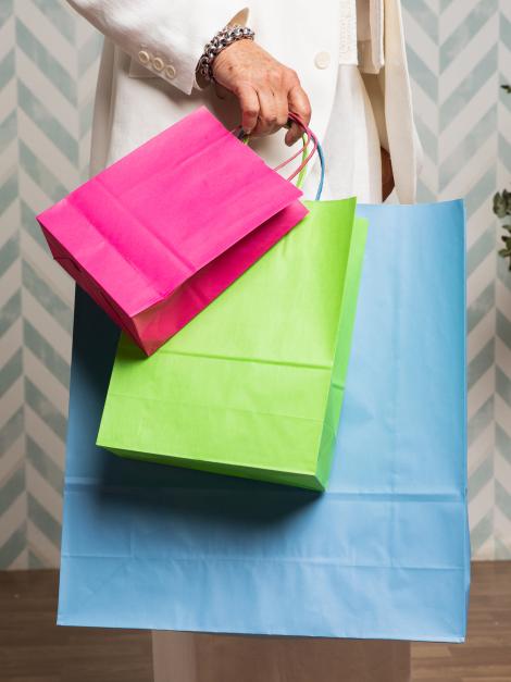 Una mujer sujetando bolsas de papel de colores