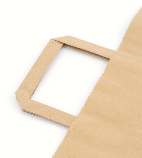 Bolsas de papel con asas planas junto a unos zapatos