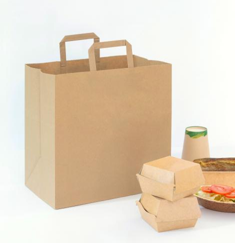 Bolsas de papel con base ancha y asas planas junto a comida