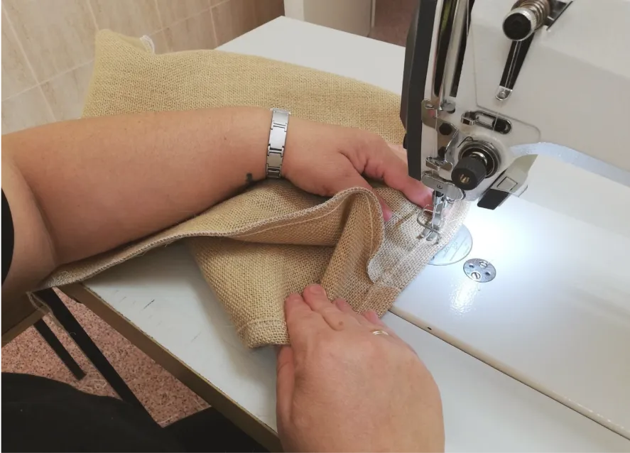 manos de mujer cosiendo en una máquina de coser