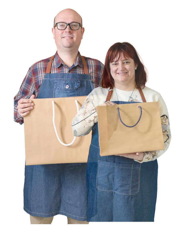 Susi y Álvaro con bolsas hechas de a mano en el taller donde trabajan